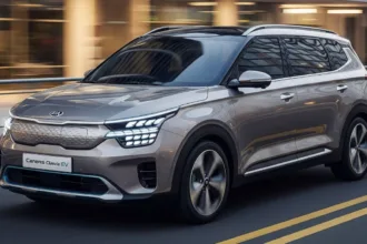 Front-side view of a silver Kia Carens Clavis EV with modern buildings in the background.